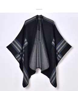 Détail de la texture en maille douce et du motif à carreaux sur le poncho femme
