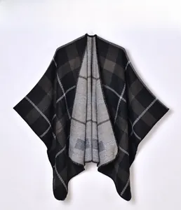 Close-up of the textured plaid knit fabric on this winter cape with fringe details