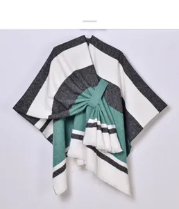 Detail of color-block knit poncho with tassel tie waist in white, grey and teal