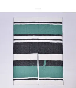 Detail of knit striped shawl with fringe trim and green grey color block patterns