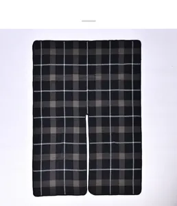Detailed view of the thick knit texture and buffalo check pattern on the plaid poncho