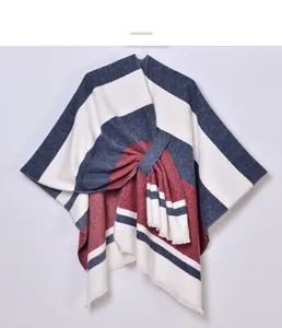 Close-up of striped knitted shawl with decorative tassels and a cross-knot detail