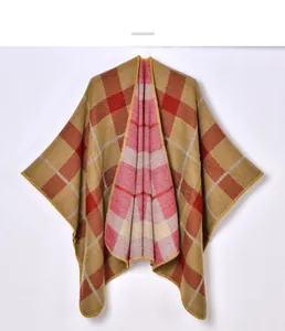 Close-up of thick knitted plaid shawl with mustard, red and beige geometric pattern