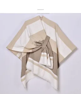 Close-up of the delicate knit texture and fringe edge of the striped tassel shawl