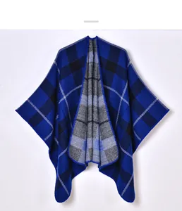 Detailed close-up of blue and black plaid knit shawl with soft cashmere-like texture