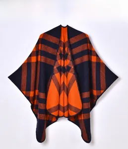 Detail of orange and dark blue plaid knit shawl with precise lockstitch edge finish