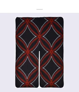 Detailed view of winter vintage knit poncho with red and white geometric patterns