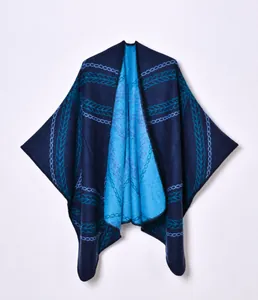 Close-up of dual-sided jacquard knit poncho featuring intricate dark and light blue patterns