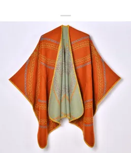 Detailed view of the double-sided orange knit shawl with yellow braided texture and blue patterns