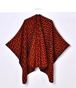 Close-up of geometric jacquard knit pattern on a red and black winter shawl wrap