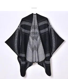 Detail of knit poncho featuring black and white jacquard pattern and soft texture
