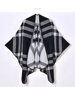Detailed close-up of knit texture and stitch finish on black grey plaid poncho