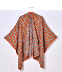 Detail of knit shawl featuring orange and blue geometric patterns and edge stitching