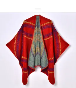 Detail of red knitted shawl featuring blue and gold chain patterns and soft fabric texture