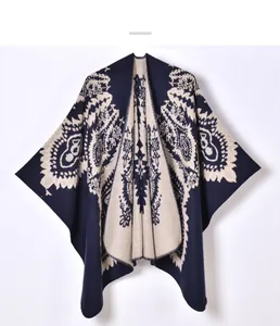 Macro view of blue paisley knit poncho showing detailed bohemian floral jacquard texture