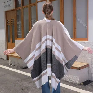 Women's long oversized knit shawl cape with tassel trim and striped pattern