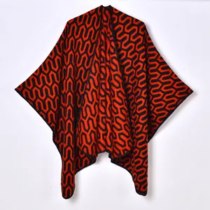 Women's knit poncho cape with red and black geometric pattern on white background