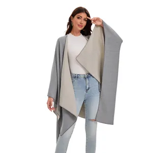Detail of soft gray and beige reversible poncho showing premium stitching and texture