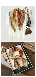 Detailed view of floral faux silk scarf featuring vibrant orange and green vintage patterns