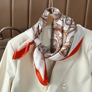 French vintage silk scarf with brown floral print and bright orange borders on white suit
