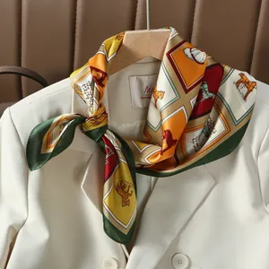 Foulard in seta con stampa equestre indossato su un blazer bianco a doppio petto
