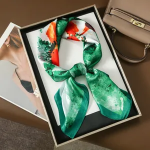 Artistic oil painting silk scarf with green and orange abstract floral patterns in a gift box