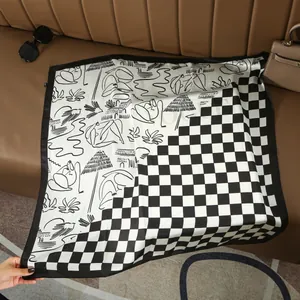 Detail of checkered silk scarf with abstract sketches on a leather background