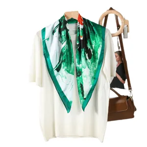 Elegant green floral silk scarf paired with a cream knit top and brown handbag