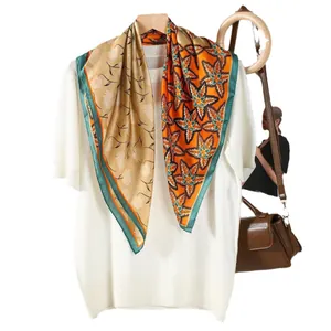 Elegant silk scarf with floral and orange maple leaf print draped over a white knit top