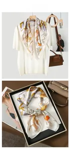 Dettaglio di un foulard in raso con fiori gialli in una confezione regalo elegante