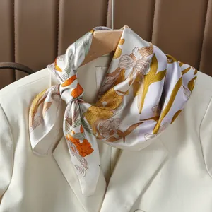 Sciarpa in seta 70cm con fiori di giglio annodata su un blazer bianco elegante