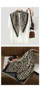 Detail of silk-feel scarf with gold geometric greek key pattern styled with a handbag
