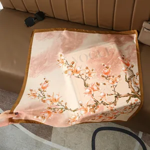 Détail de l'imprimé floral magnolia rose sur foulard en soie satinée avec bord marron