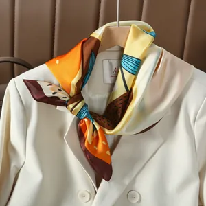 Silk-like scarf with abstract floral print styled on a beige double-breasted blazer