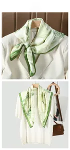 Floral print green silk scarf accessory styled with an elegant cream-colored suit blazer