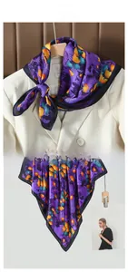 Detail of silk scarf with purple ginkgo leaf print paired with a beige suit blazer