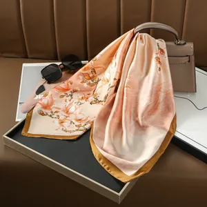 Élégant foulard en satin à imprimé fleurs de prunier sur un plateau avec accessoires