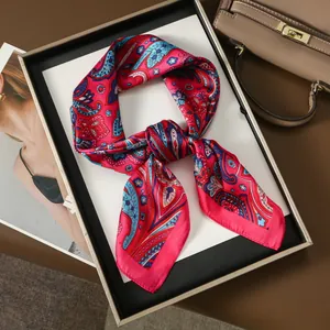 Magenta silk scarf with paisley patterns artfully knotted on a stylish background
