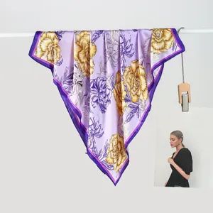 Detail of elegant light purple silk scarf featuring bright yellow floral patterns and dark borders
