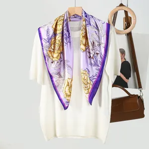Detail of floral silk scarf with purple and yellow flower print and purple edge piping