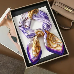 Detailed close-up of a purple floral silk scarf with yellow and orange blossom print