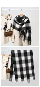 Detail of classic black and white plaid scarf with fringe on a beige autumn coat