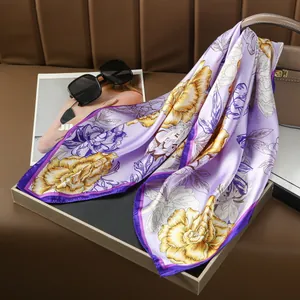 Detail view of floral print silk scarf in purple with vibrant yellow flower pattern