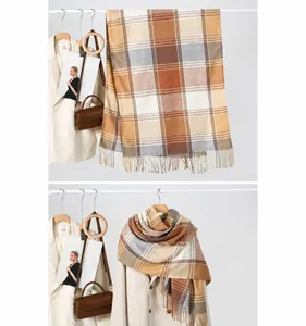 Detailed view of plaid scarf with tassels and autumn colors paired with a beige coat