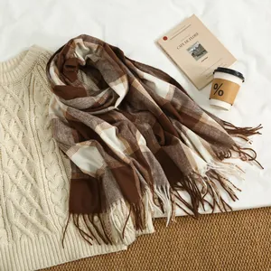 Detail of soft thick plaid scarf with tassels styled with cream cable knit sweater