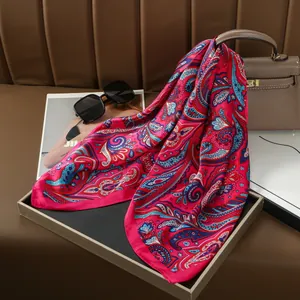 Elegant fuchsia paisley silk scarf styled with luxury accessories and leather background