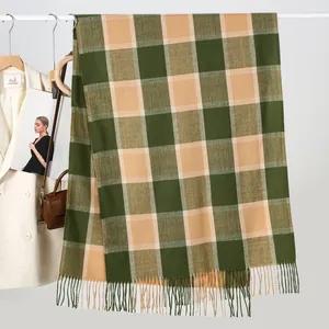 Detail of dark green and khaki plaid cashmere scarf with soft tassels on a white hanger
