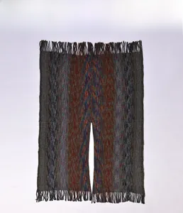Détail du poncho en maille avec texture space-dye, franges et motifs rayés