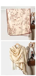 Detail of cream cotton linen scarf with brown floral prints and delicate hemmed edges