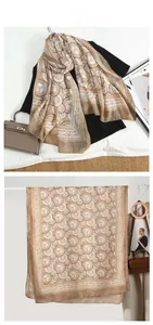 Detail view of champagne gold vintage print scarf with classic badge patterns and striped edges